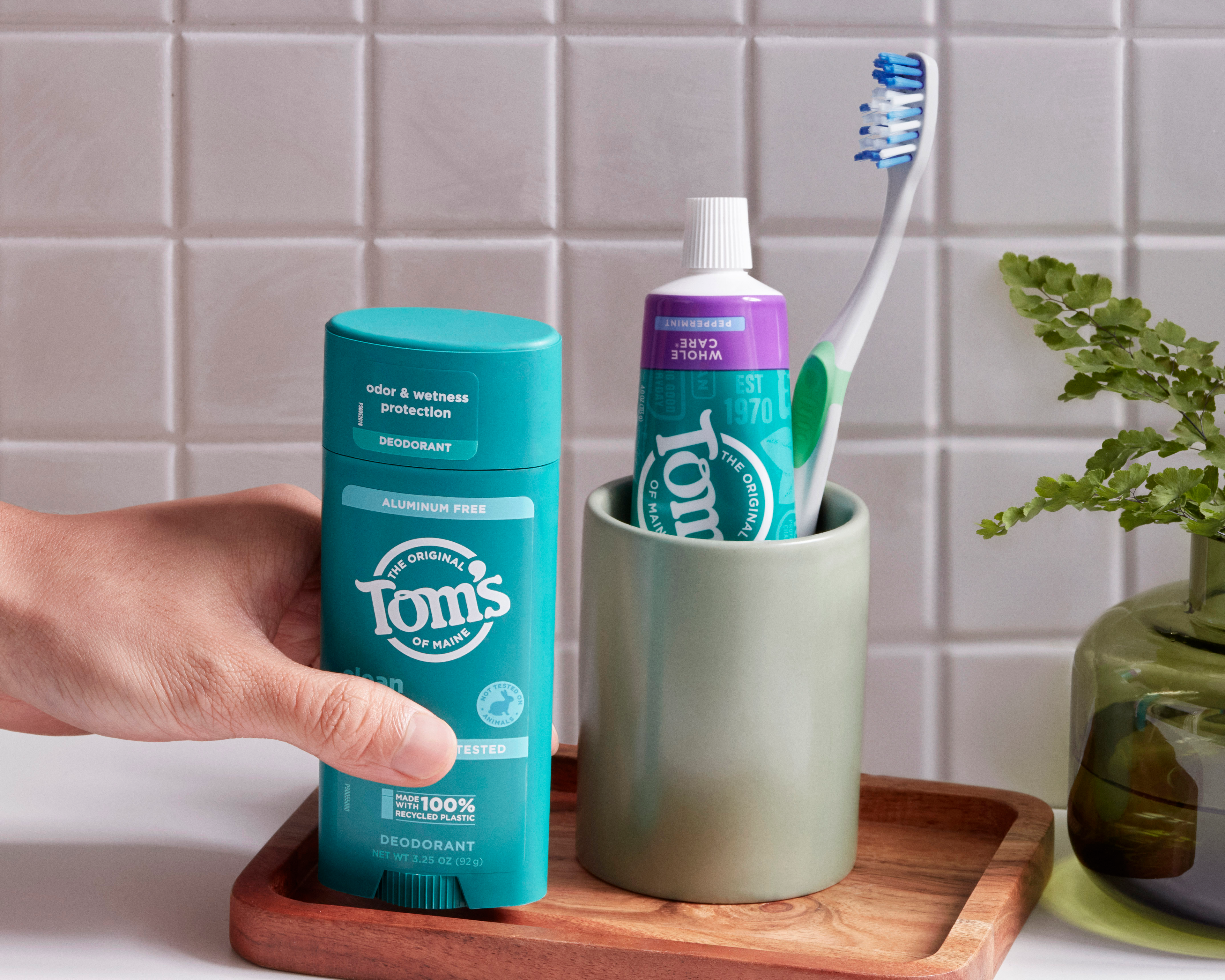 Tom's of Maine deodorant, toothpaste, and toothbrush on a bathroom counter, highlighting eco-friendly packaging and natural personal care products